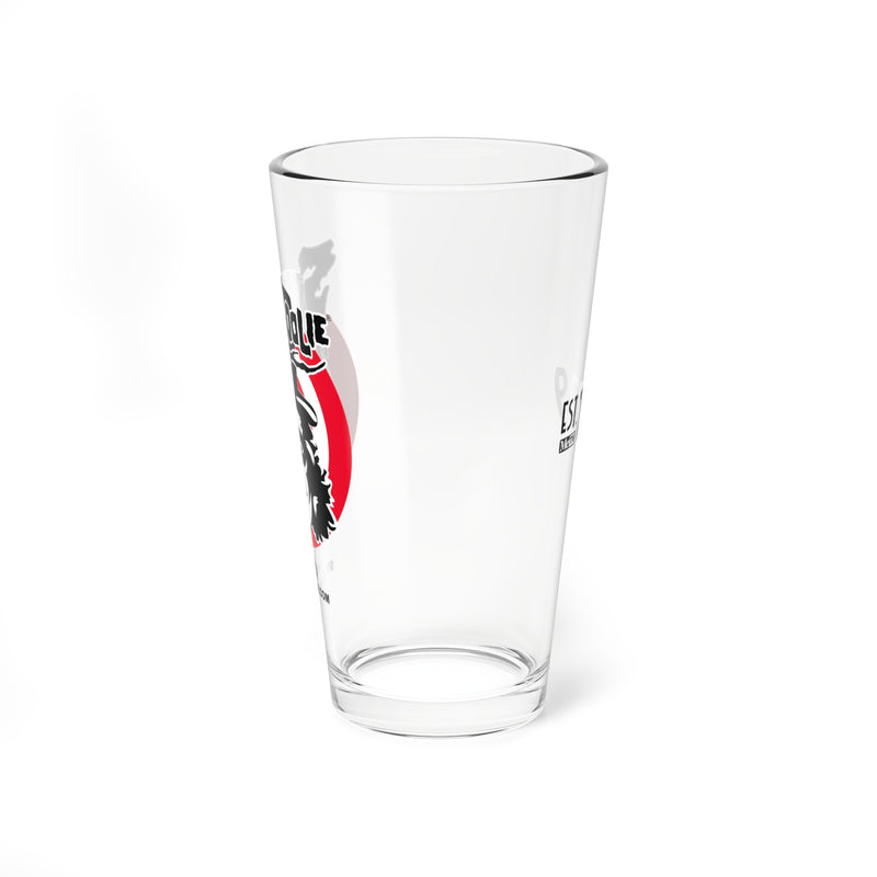 Left side view of the Svengoolie pint glass showing the face logo in a red circle, with faint text on the opposite side.