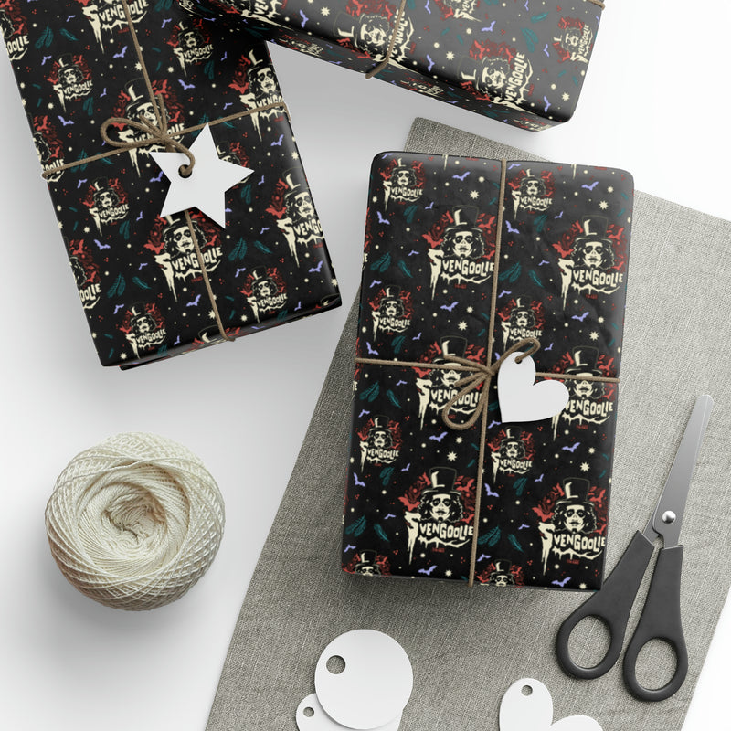 Two gift boxes wrapped in Svengoolie wrapping paper, one with a white star tag and one with a white heart tag, beside scissors and twine.