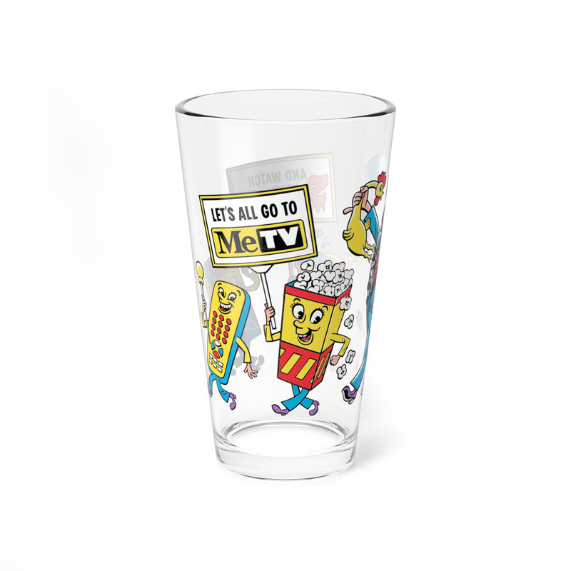 Side view of Svengoolie pint glass showing a remote control character holding a sign that reads 'LET'S ALL GO TO MeTV' beside a popcorn box character.