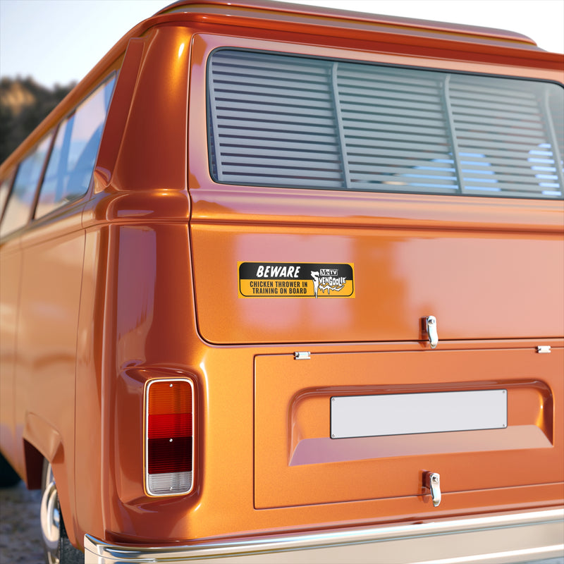 Rear of an orange van showing the Svengoolie bumper sticker mounted on the back door above the license plate area.