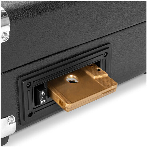 Close-up of a gold cassette tape loaded into the cassette deck on the side of the black Victrola record player.