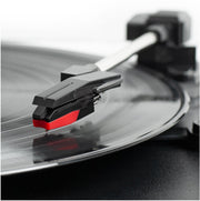 Close-up of the black and red stylus on the tonearm resting on a black vinyl record of the Victrola record player.