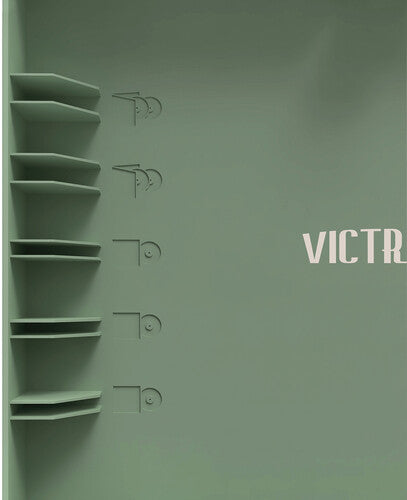 Close-up of record storage shelves and embossed record icons on the lid of basil green record player, with cream lettering reading 'VICTR' partly cropped.