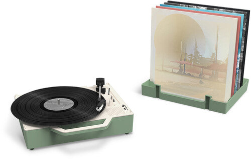 Basil green record player beside a matching stand holding vinyl albums upright in its slots.