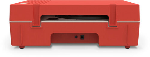 Back of the red record player showing two black power and audio jacks on the rear panel below the turntable.