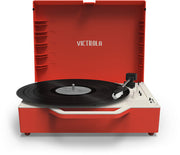 Front view of the open red record player with a black vinyl record on the platter and the text 'VICTROLA' in white on the inside of the lid.