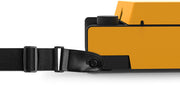 Close-up of the black shoulder strap attached to the orange Victrola Revolution GO case with a black leather loop and buckle.