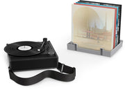 Gray and black record player beside a gray record holder storing several colorful vinyl album covers