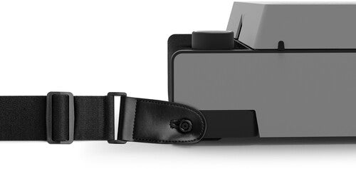 Close-up of black shoulder strap attached to the side of the gray record player with a black leather strap clip