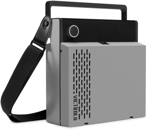 Angled view of gray portable record player with black carrying handle and shoulder strap, and the text 'VICTROLA' in black running vertically on the side