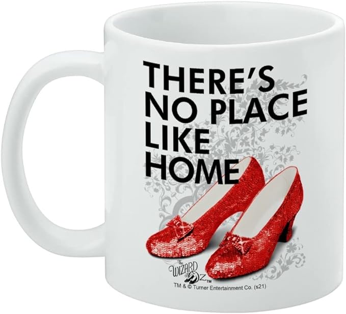 Left side of the mug showing the handle, with the 'THERE'S NO PLACE LIKE HOME' text in black and red ruby slippers on the right side of the design.