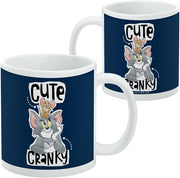 Back of the Tom and Jerry Cute & Cranky mug beside a second mug, showing the navy design wrapping around with a small copyright line near the base.