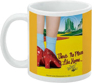 Left side view of the Wizard of Oz mug showing ruby slippers on a yellow brick road beside the text 'There's No Place Like Home' in red script.