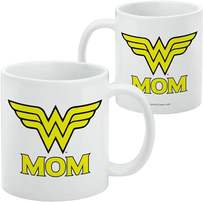 Two white Wonder Woman Mom mugs side by side, with the same yellow emblem and 'MOM' design on both, and a DC Comics copyright line on the right mug.