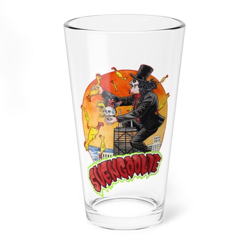 Clear pint glass featuring Svengoolie on top of a building with rubber chickens and an orange sun and the text Svengoolie in red below.