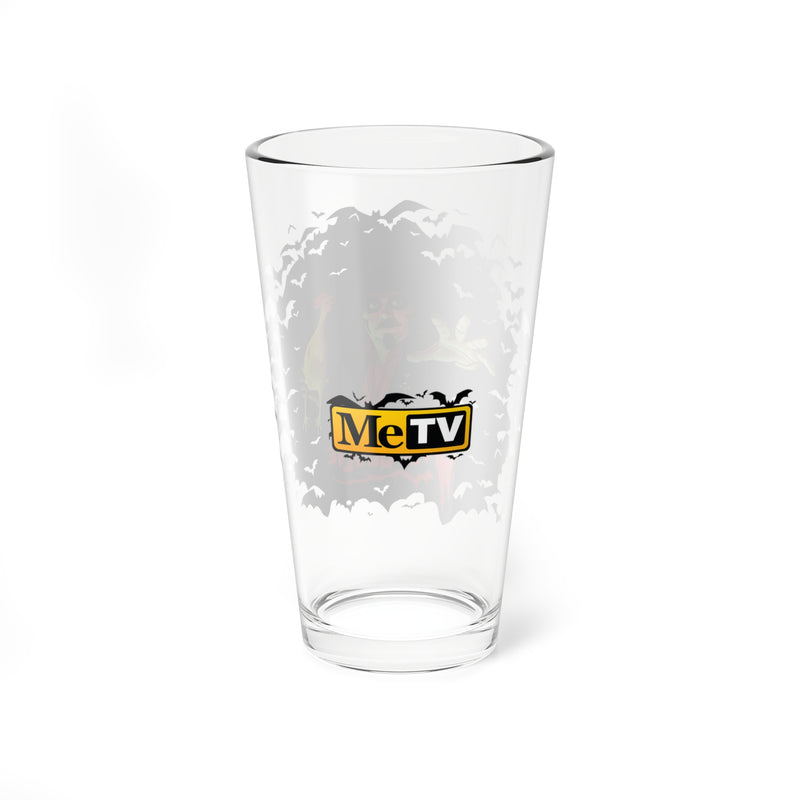 Back of the Svengoolie pint glass showing a faint bat and character design through the glass, with a centered yellow and black MeTV logo.