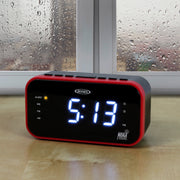 Jensen clock radio on a wooden table in front of a rainy window, showing a blue LED display and an amber ALERT light lit.