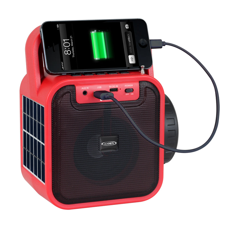Red Jensen portable radio speaker charging a smartphone resting on top through a USB cable plugged into the front control panel.