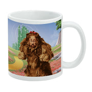 White ceramic mug featuring the Cowardly Lion from The Wizard of Oz walking through a red poppy field toward the Emerald City.