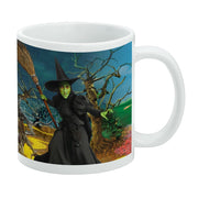 Side view of white mug featuring the Wicked Witch of the West holding a broom in a painted Oz landscape with twisted trees