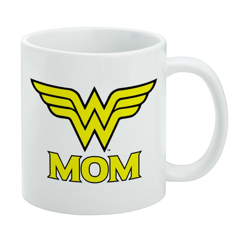 White ceramic mug featuring the Wonder Woman wing emblem with the text 'MOM' in yellow below it.