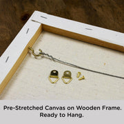 Close-up of the back of the Flash art by numbers canvas showing pre-stretched canvas on a wooden frame with brass hanging hooks, D-rings, and wire for hanging.