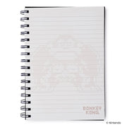 Right side of the notebook showing a lined page with faint Donkey Kong pixel artwork and a small red 'DONKEY KONG' logo in the lower right.