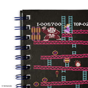 Close-up of the top left of the cover showing Donkey Kong beside stacked barrels and Pauline on a red girder.