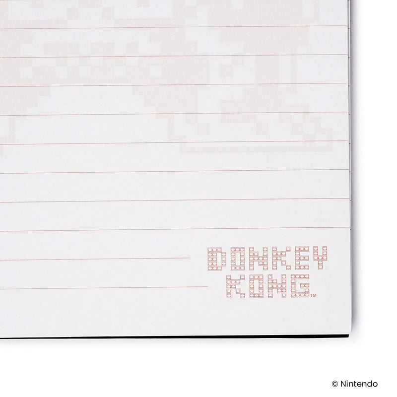 Close-up of a lined page corner with faint pixel artwork and a small red 'DONKEY KONG' logo in the lower right.