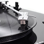 Close-up of the silver tonearm and white Audio-Technica cartridge resting on a black vinyl record on the Studebaker turntable.