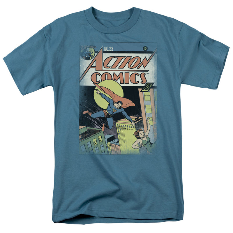 Slate blue t-shirt featuring Superman flying over a city on Action Comics No. 23 cover art with the text 'Action Comics' in orange at top.
