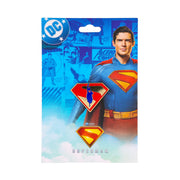 Packaging card for the Superman enamel pins showing the flying logo pin above a standard Superman shield pin, with the text 'SUPERMAN' at the bottom.