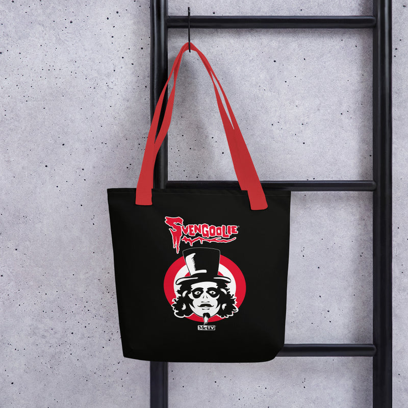 Black tote bag with red handles hanging on a black ladder, featuring the Svengoolie face logo in a red circle with the text 'Svengoolie' in red above it.