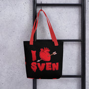Black tote bag with red handles featuring a red heart pierced by an arrow with the text 'I' and 'SVEN' in red dripping letters below, forming 'I Heart Sven'.