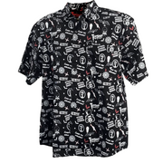 Front view of black short-sleeved button-up shirt featuring an all-over print of the Svengoolie face, bats, coffins and 'MeTV' logo in white.