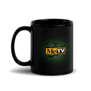 Black glossy ceramic mug with a green glow and a flock of bats around the MeTV logo, which has the text 'MeTV' in black and white on a yellow badge.