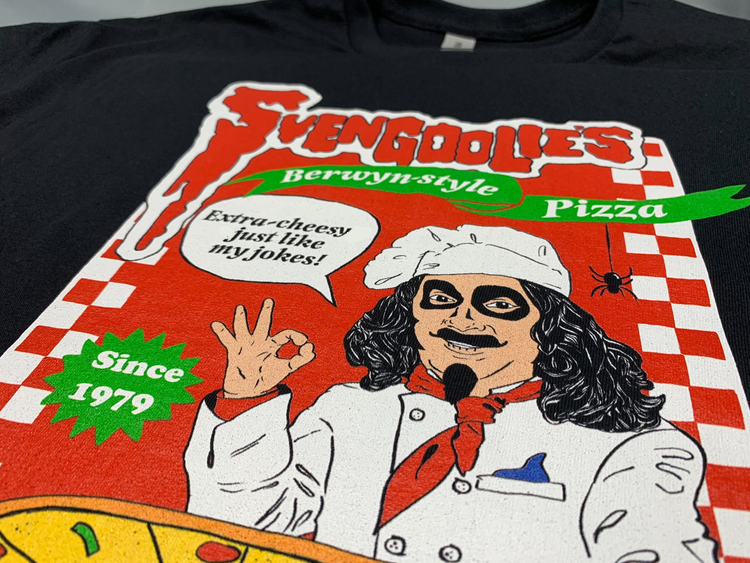 Close-up of black t-shirt featuring Svengoolie as a pizza chef with the text 'Svengoolie's' in red and a green banner reading "Berwyn Style Pizza"