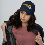 Model wearing a navy dad hat featuring the Collector's Call logo with the text 'Collector's' in yellow above 'Call' in blue.