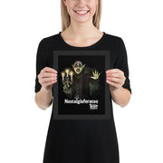 Model holding the framed Nostalgiaferatoo art print showing the vampire artwork and the white text 'Nostalgiaferatoo' on the black background.