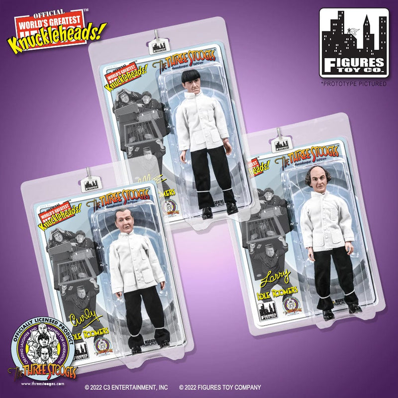 Three boxed Three Stooges 8 inch action figures in white Idle Roomers housekeeper uniforms, Moe, Curly, and Larry, with 'The Three Stooges' logo in red and yellow on each card.