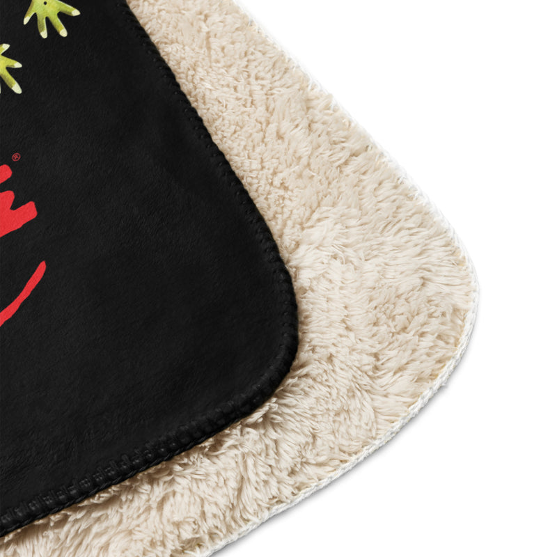 Close-up of corner of black sherpa throw blanket featuring the Svengoolie graphic with the text 'Svengoolie' in red lettering, with cream sherpa border.