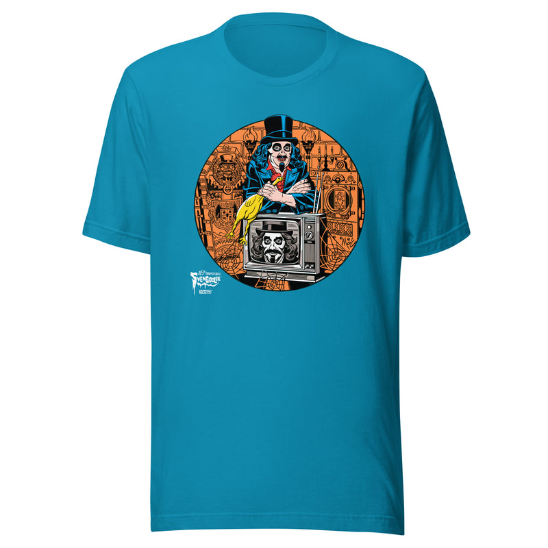 Aqua t-shirt featuring Svengoolie holding a rubber chicken, by a TV with Orange circle border. Svengoolie logo at lower left.