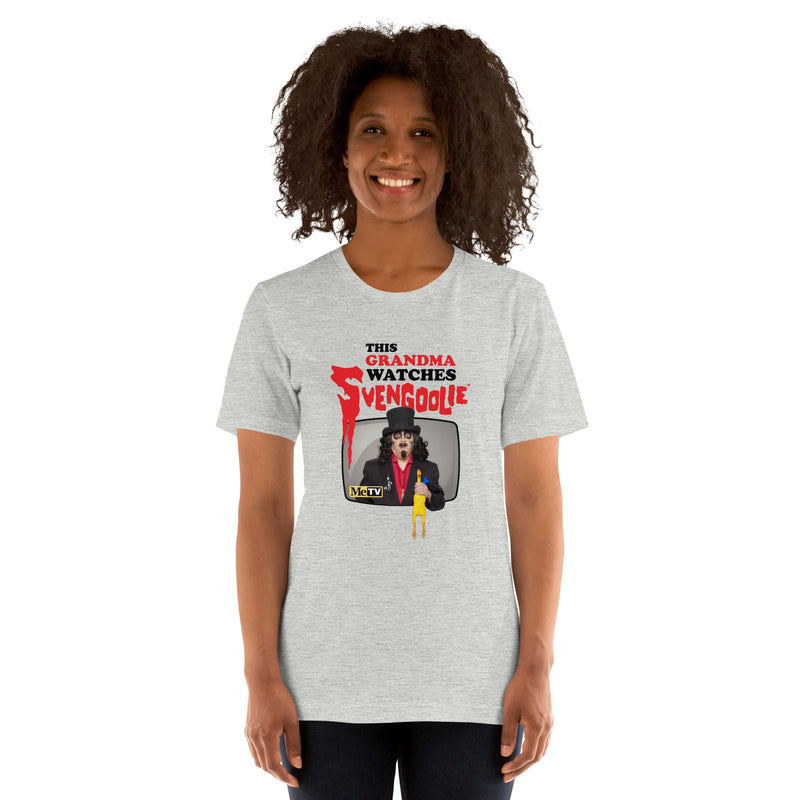 Model wearing gray t-shirt featuring Svengoolie holding a rubber chicken with the text 'This Grandma Watches Svengoolie' in black and red above it.