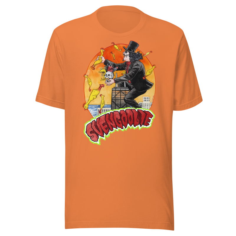 Orange t-shirt featuring Svengoolie climbing a skyscraper and holding a skull among flying yellow chickens with the text 'SVENGOOLIE' in red below it.