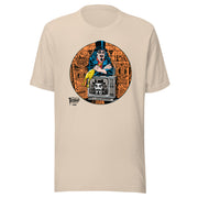 Tan t-shirt featuring Svengoolie holding a rubber chicken, by a TV with Orange circle border. Svengoolie logo at lower left.