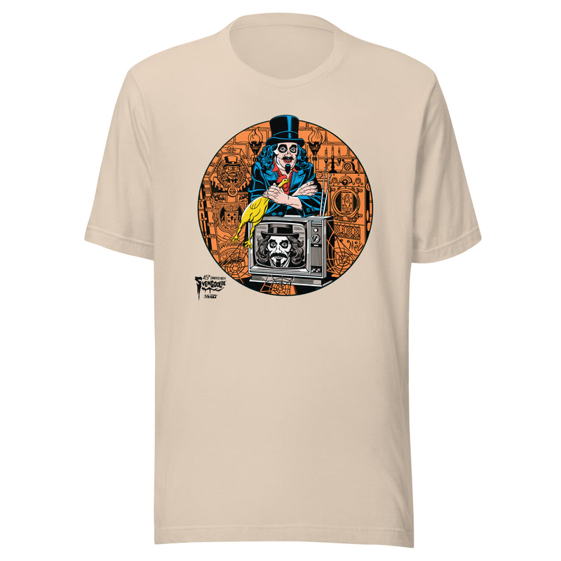 Tan t-shirt featuring Svengoolie holding a rubber chicken, by a TV with Orange circle border. Svengoolie logo at lower left.