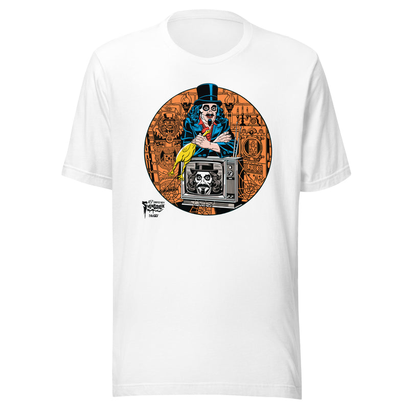 White t-shirt featuring Svengoolie holding a rubber chicken, by a TV with Orange circle border. Svengoolie logo at lower left.
