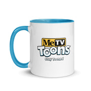 White ceramic mug with blue handle and blue interior featuring the MeTV Toons logo with the text 'Stay Tooned' in black below it.