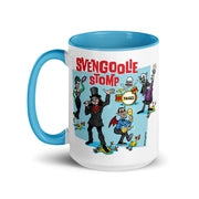 White mug with blue handle and interior featuring a cartoon band of Svengoolie characters with red SVENGOOLIE STOMP text and Svengoolie logo to left