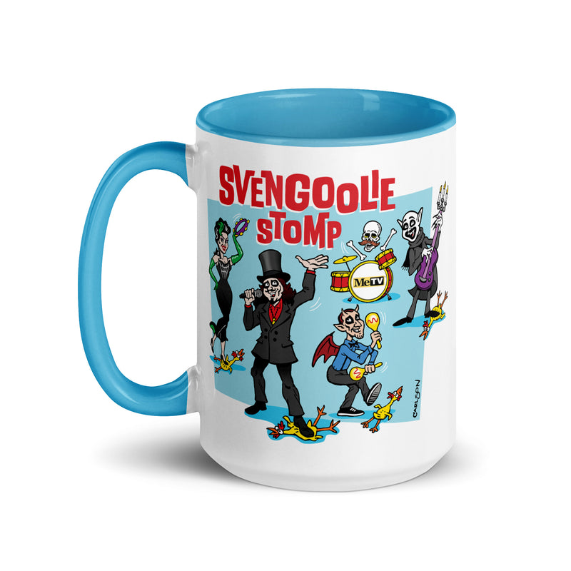 White mug with blue handle and interior featuring a cartoon band of Svengoolie characters with red SVENGOOLIE STOMP text and Svengoolie logo to left